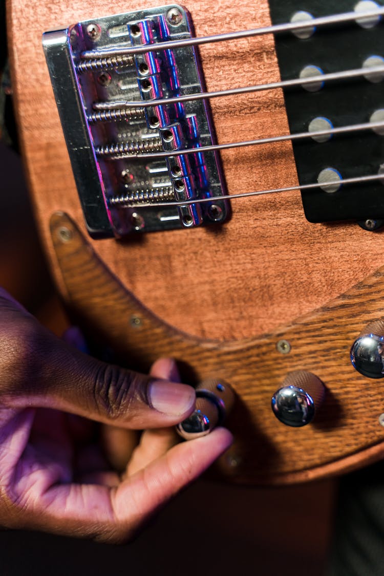 A Person Tuning An Acoustic Guitar