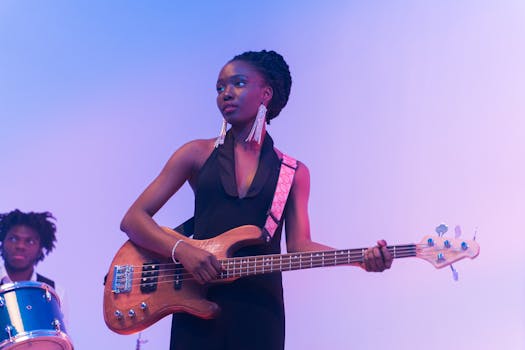 African American woman playing bass guitar on a vibrant stage.