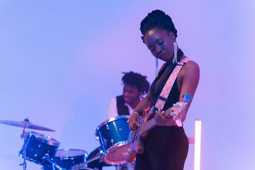 Two musicians in a vibrant indoor setting, playing bass guitar and drums passionately.