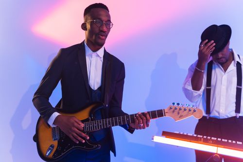 Free Two musicians performing with electric guitar in vibrant setting. Stock Photo