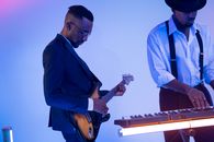 Man in Blue Suit Playing Electric Guitar and Man in White Dress Up Shirt Playing Electronic Keyboard