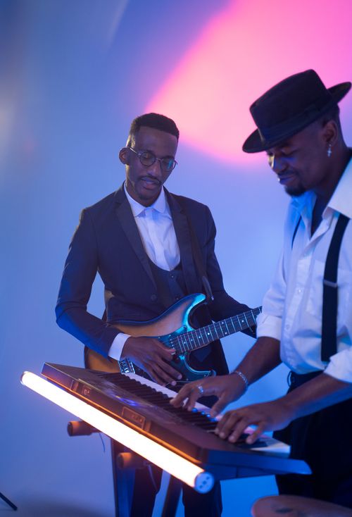 Free Professional musicians performing with guitar and keyboard under colorful stage lights. Stock Photo