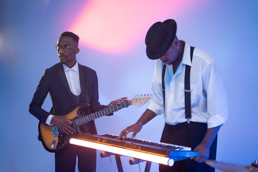 Two musicians playing electric guitar and keyboard on stage with vibrant lighting.