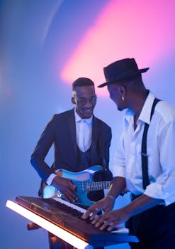 Two musicians performing with guitar and keyboard under vibrant stage lights.