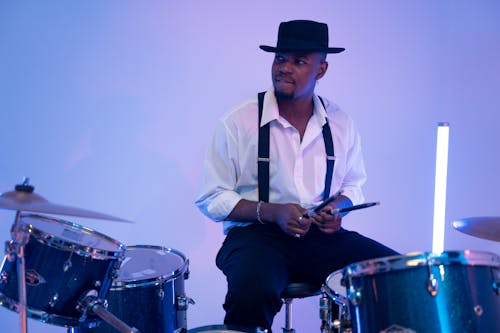 Man Holding the Drumstick In Front of the Drums