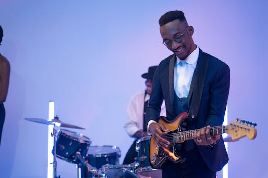 Stylish African American guitarist playing electric guitar with a band.