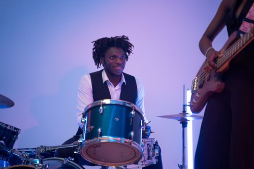 Free Two musicians playing drums and bass guitar in a live performance setting. Stock Photo