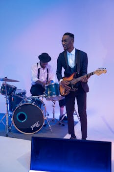 A band performance featuring a guitarist and drummer in a stylish setting.