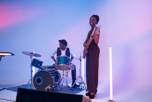 Free Captivating indoor music performance featuring a drummer and a guitarist in a colorful setting. Stock Photo