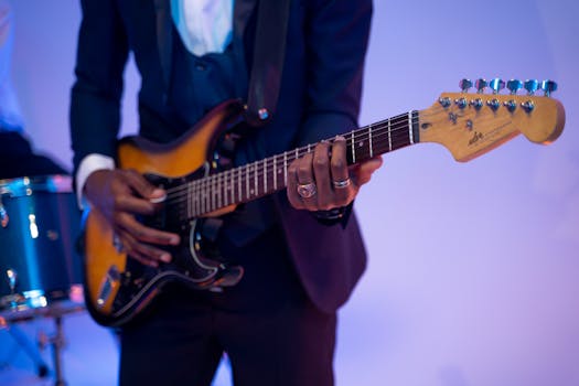 Musician playing electric guitar at a live indoor concert.