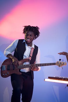 Musician playing electric bass guitar with vibrant lighting backdrop, conveying energy and joy.