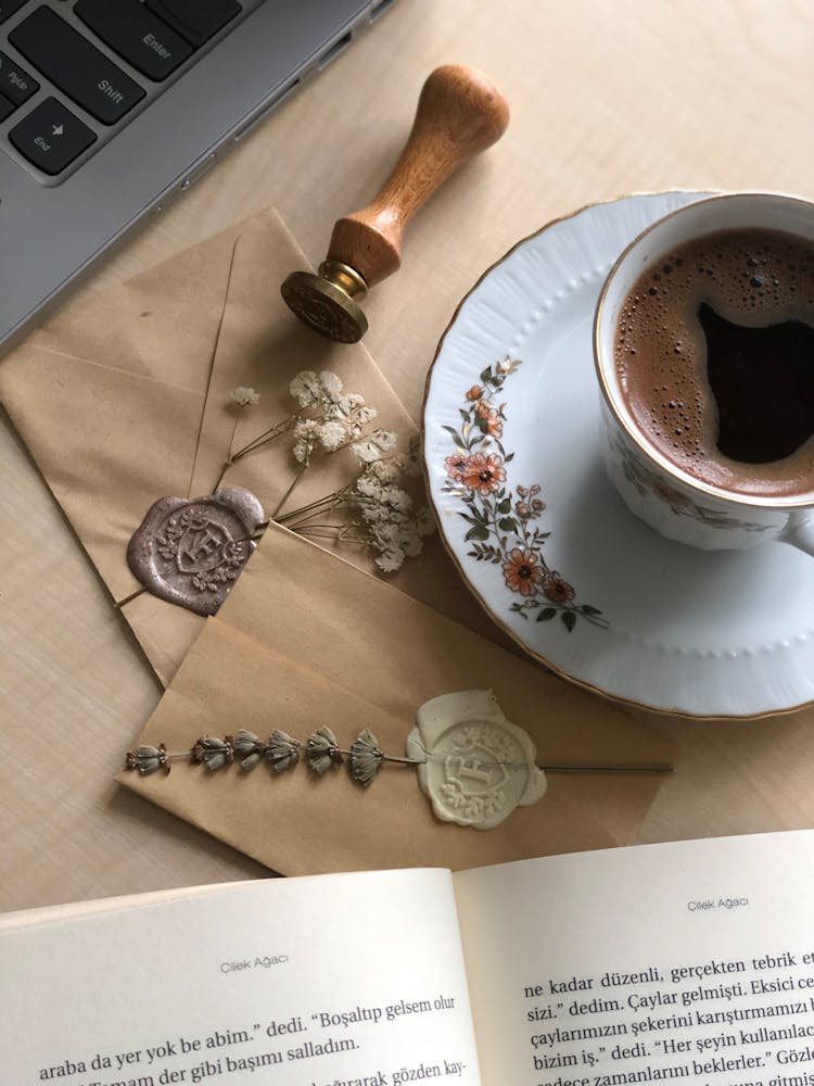 A Cup Of Coffee Beside A Seal Stamp And Sealed Letter