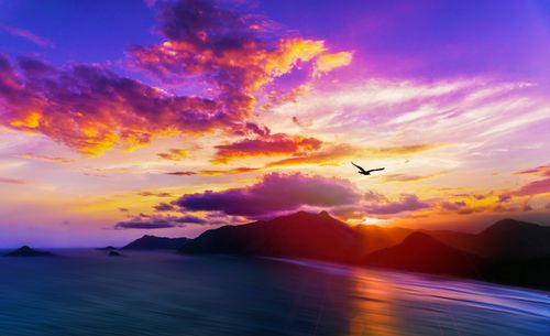 Free Stunning sunset view over the Rio de Janeiro coastline with vibrant skies and distant mountains. Stock Photo