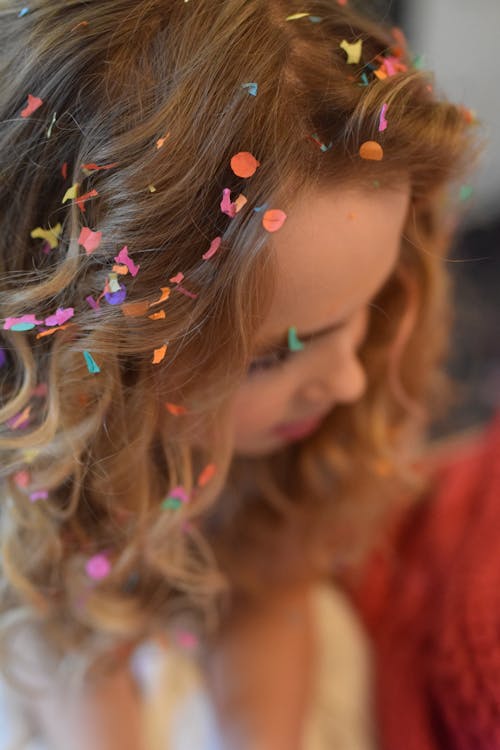 浅棕色头发的女人，头发上五彩纸屑的聚焦摄影