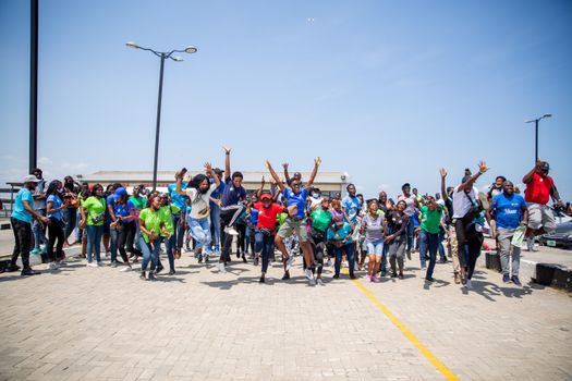 A diverse group of happy adults jumping and celebrating together outdoors.