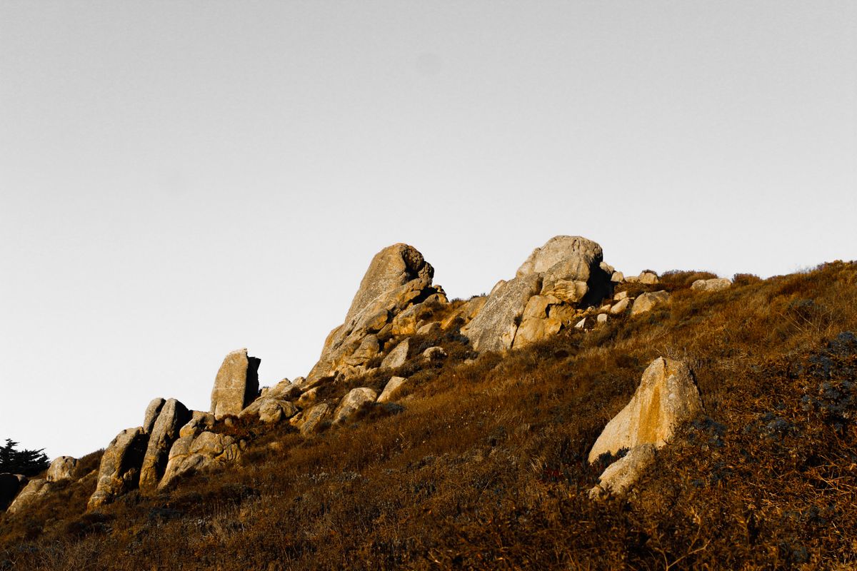 A hill with rocks on the summit, seen from below