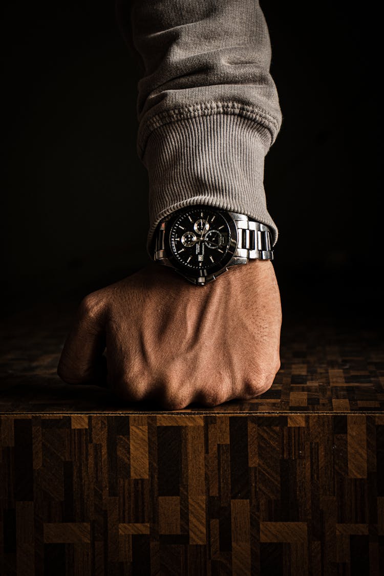 A Person Wearing A Black And Silver Chronograph Watch