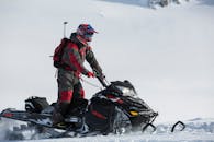 雪地摩托车穿着防护装备和头盔在雪地上行驶