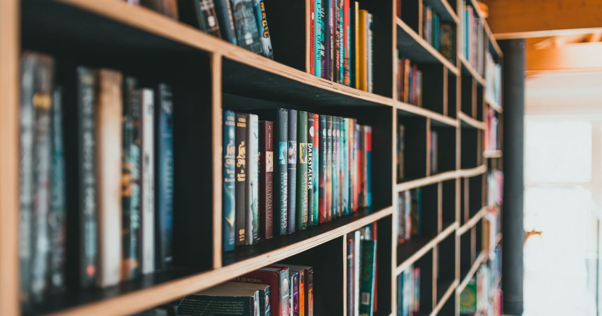 Close-up of wooden shelves packed with colorful books in a bright library