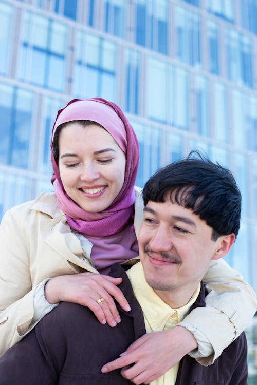 A Woman in Pink Hijab Hugging a Man from Behind