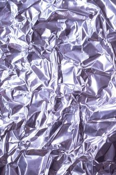Close-up of wrinkled metallic aluminum foil creating a shiny textured surface.