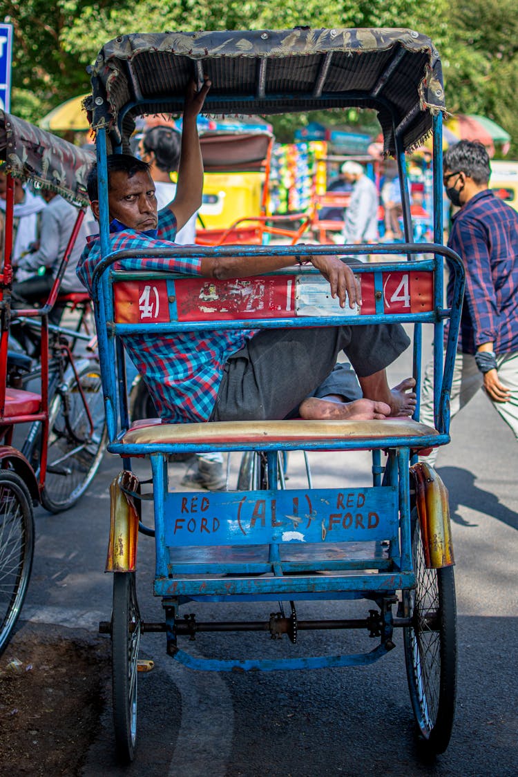 A Man Sitting On The Passenger Seat Of A Rickshaw Three Wheeler Bicycle