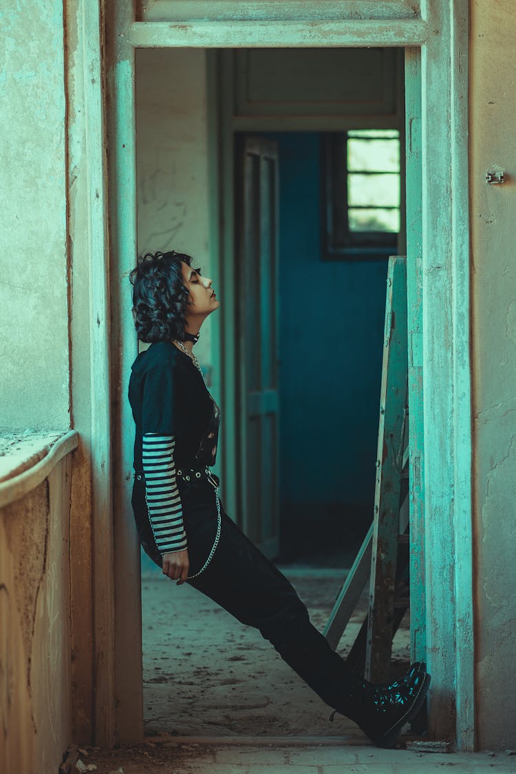 A Side View Of Woman In Black Pants Leaning On The Wall