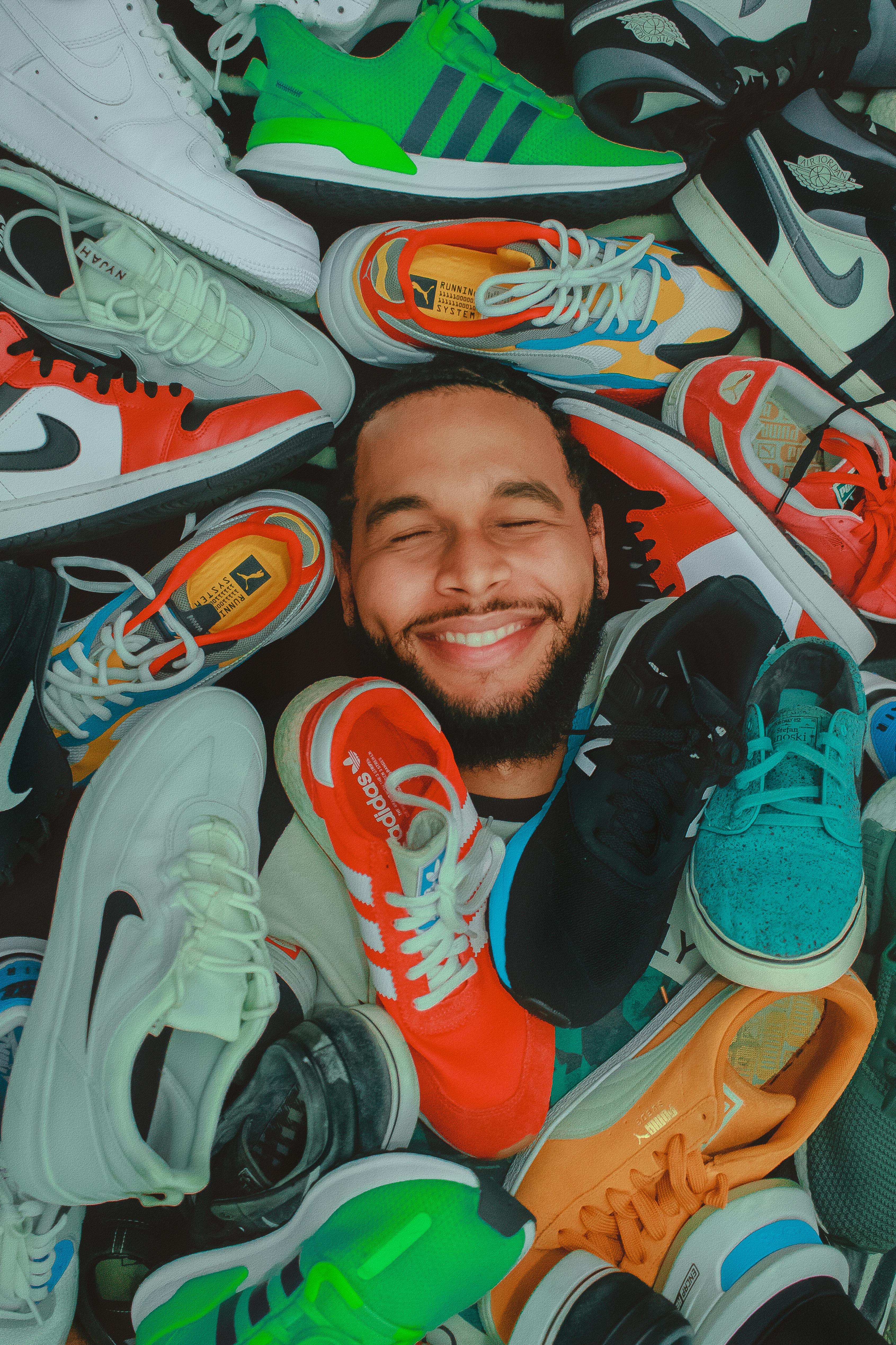 a happy man surrounded by shoes