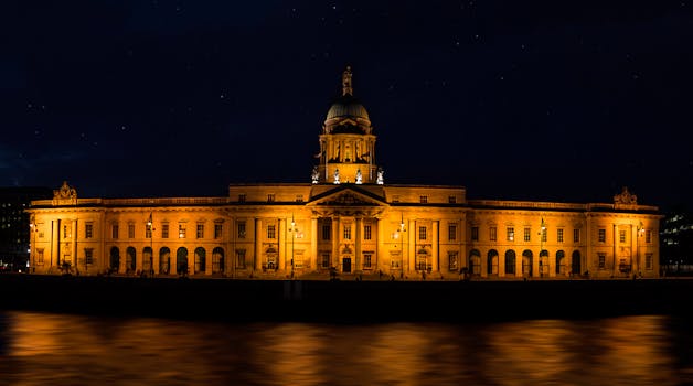 Stunning view of the illuminated Custom House in Dublin by the river at night.