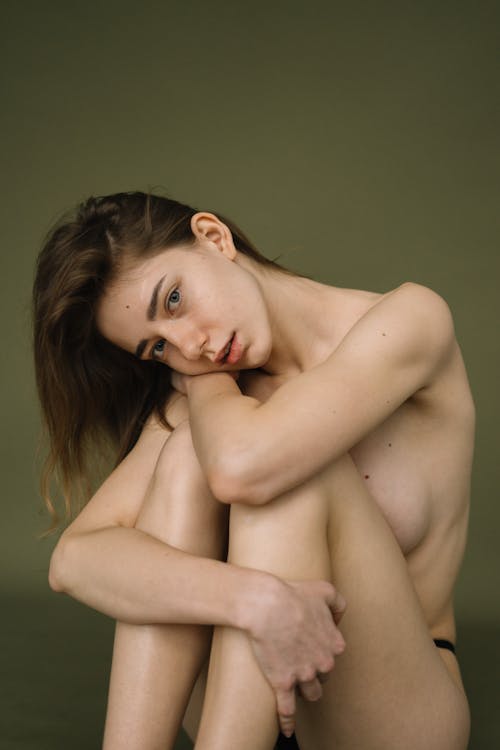 A Topless Woman Sitting on the Floor