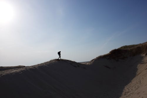 Silhouette of a Person Walking on a Desert