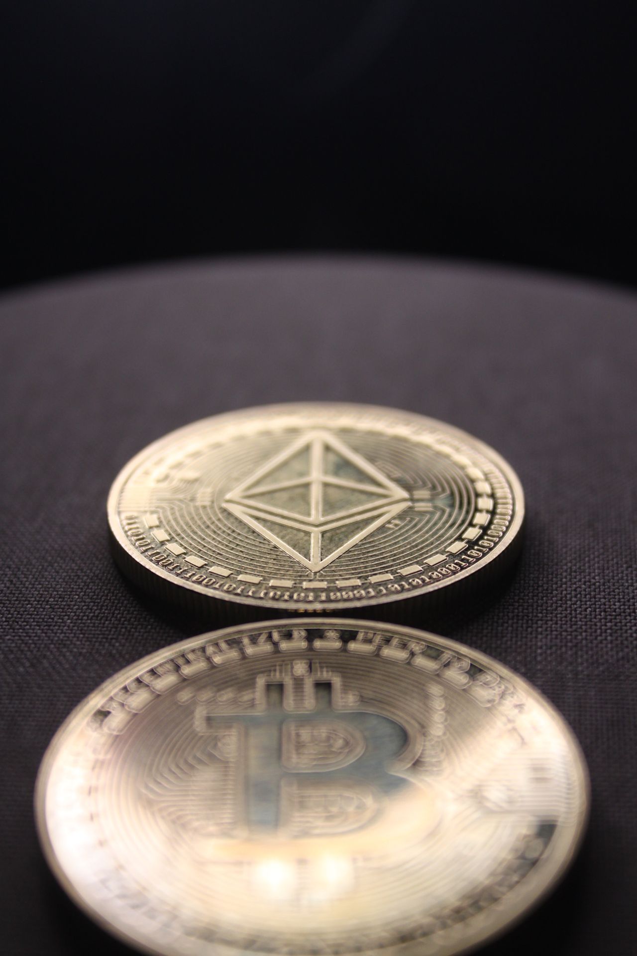 Detailed shot of Bitcoin and Ethereum coins on a dark surface