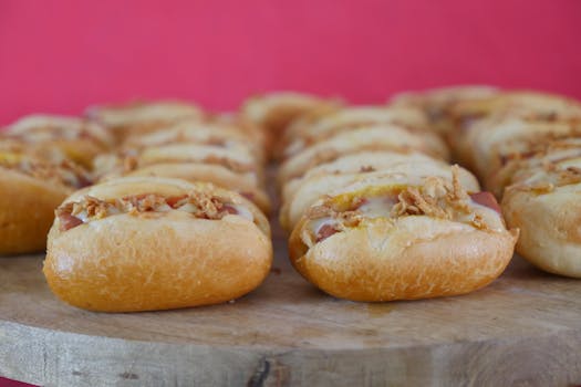Close-up of delicious mini hotdogs topped with crunchy onions and cheese.