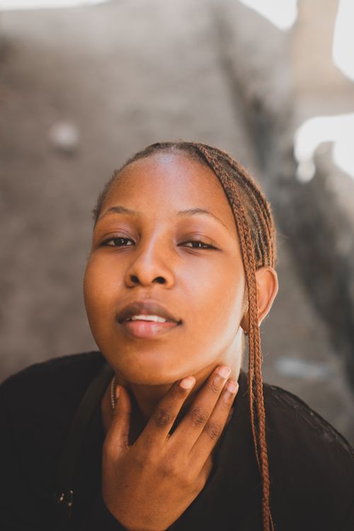 Free Close-up portrait of an African woman with braided hair, outdoors. Stock Photo