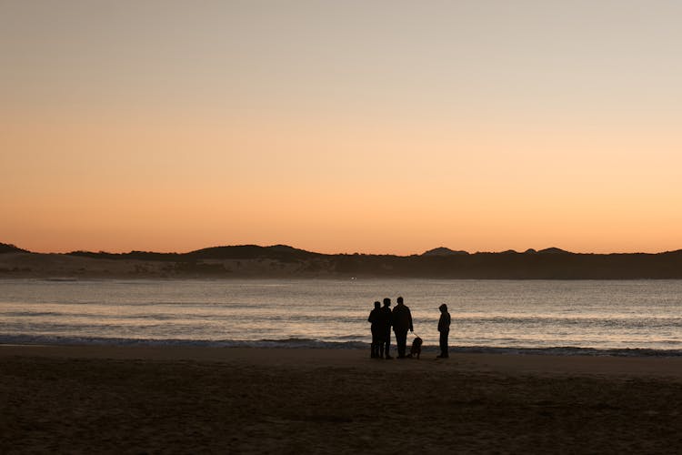 Silhouette Of People At The Beach