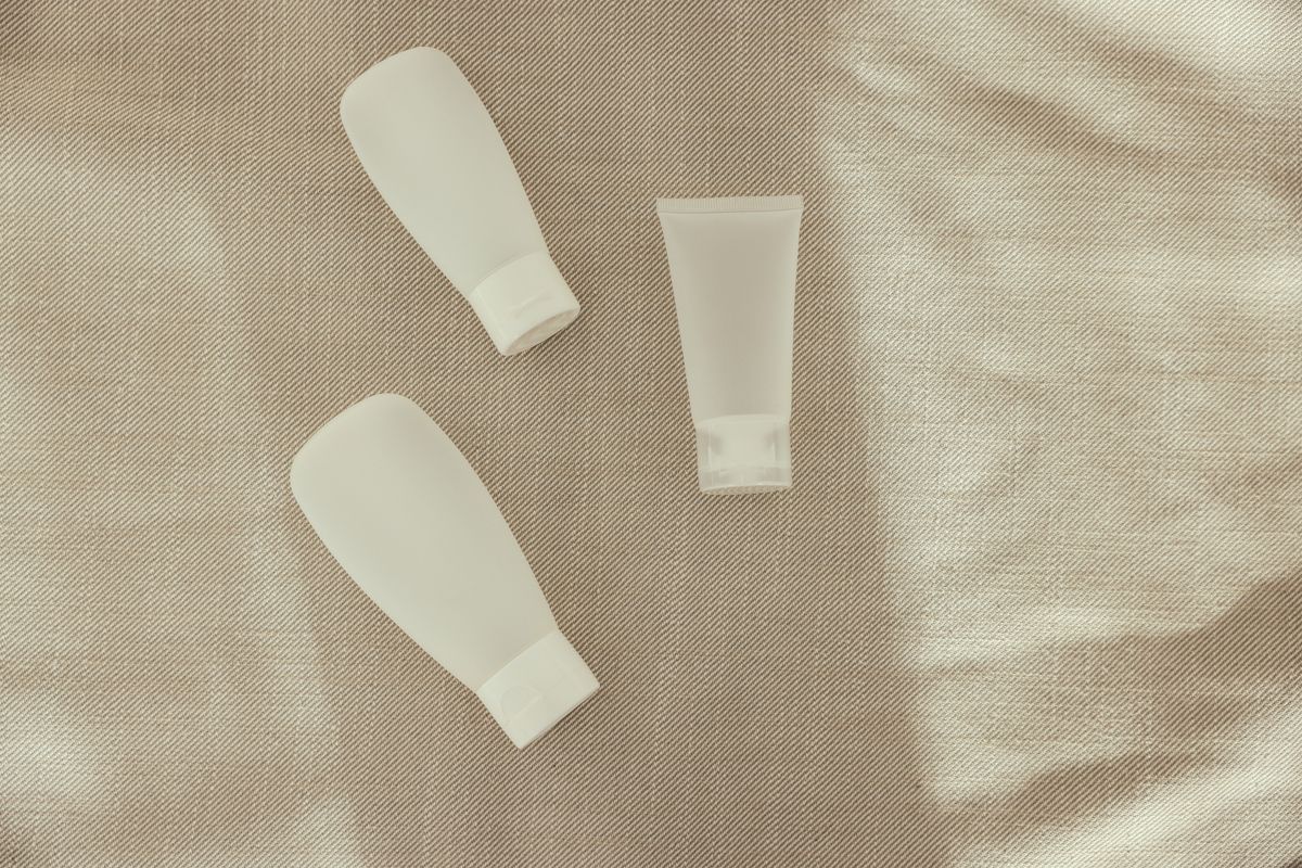 Unlabelled cream tubes laid out on linen. Photo by Cup of Couple on Pexels