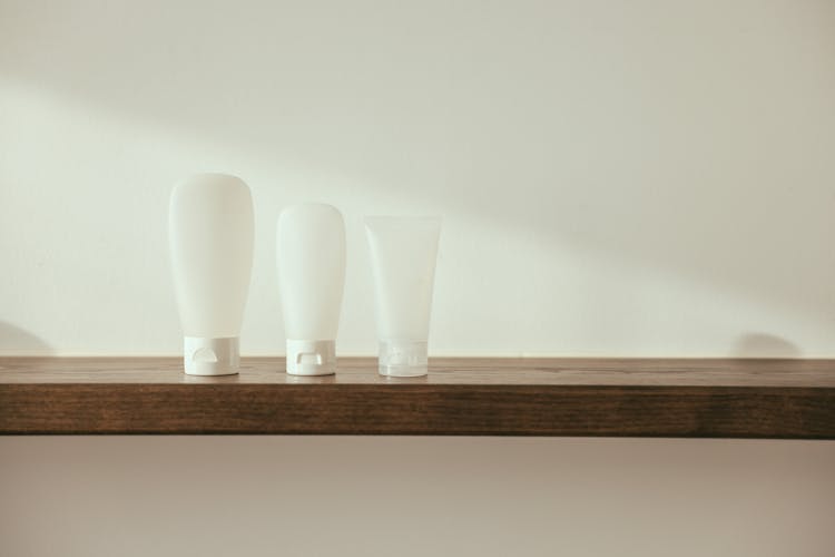White Plastic Tube And Bottles On The Wooden Table