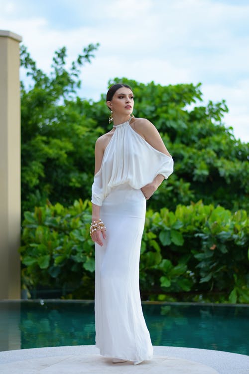 Woman in White Long Dress Standing Beside the Pool