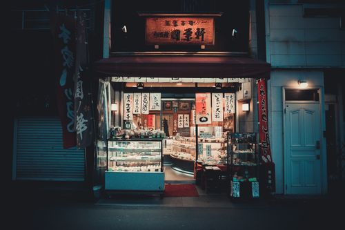 Free Illuminated traditional Japanese storefront in Kyoto featuring banners and signage at night. Stock Photo