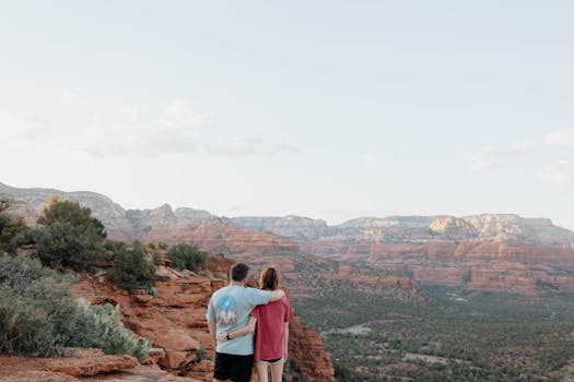 A couple embraces while enjoying the scenic view of Sedona's red rock formations.