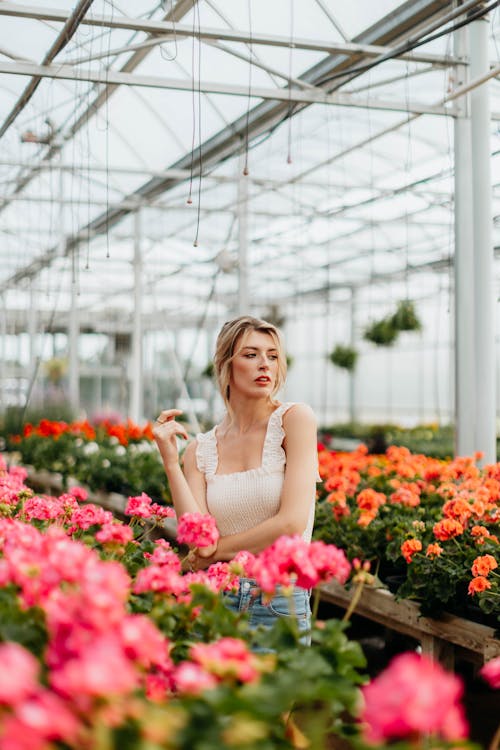 Pretty Woman Standing near the Blooming Pink Flowers