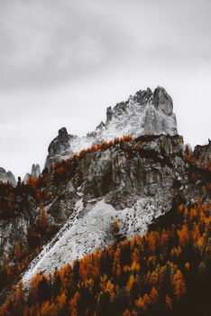 Stunning autumn view of a rugged mountain surrounded by colorful trees.
