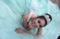 一位穿着优雅蓝色礼服的年轻美丽女子在室内微笑着摆姿势