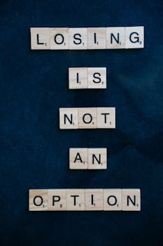Inspiring message 'Losing is not an option' spelled with Scrabble tiles on a dark surface.