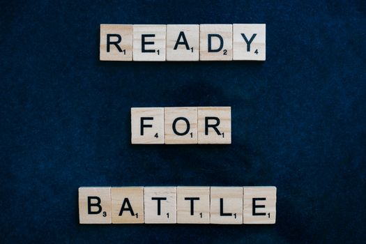 Scrabble tiles spell 'Ready for Battle' on a blue background, symbolizing motivation and readiness.