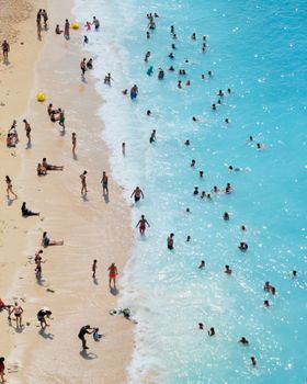 Vibrant aerial view of Antalya's beach in Türkiye, capturing summer vacationers enjoying the sea.