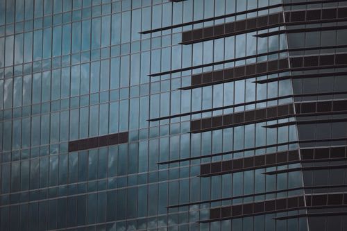 Free Close-up view of modern glass facade with reflections on an urban skyscraper. Stock Photo