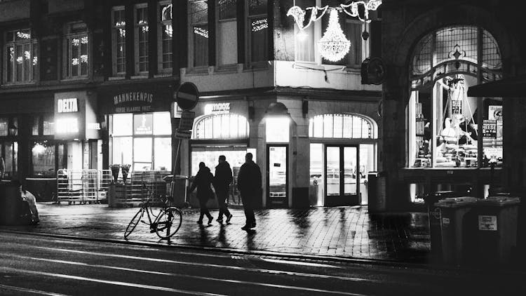 People Walking On Street Along Old Brick Buildings