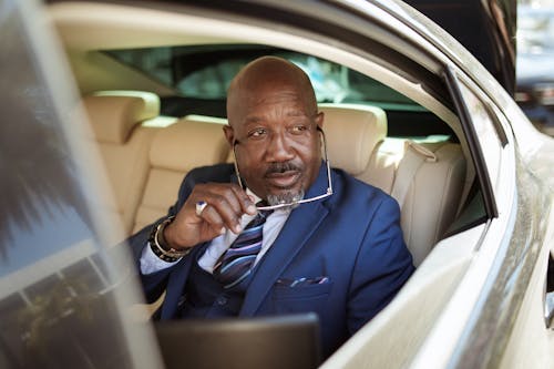 Man in Blue Suit Sitting on Car Seat