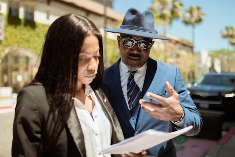 A Man And Woman Talking On The Street About Work